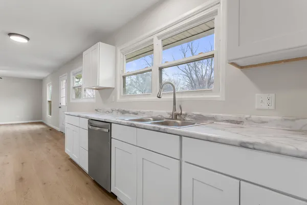 a kitchen with stainless steel appliances granite countertop a sink and a window