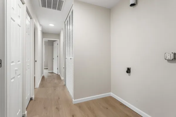 a view of a hallway with wooden floor