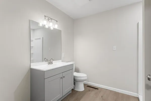 a bathroom with a toilet a sink and mirror