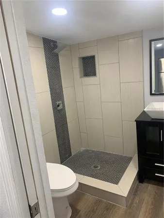 a bathroom with a sink a toilet a window and vanity
