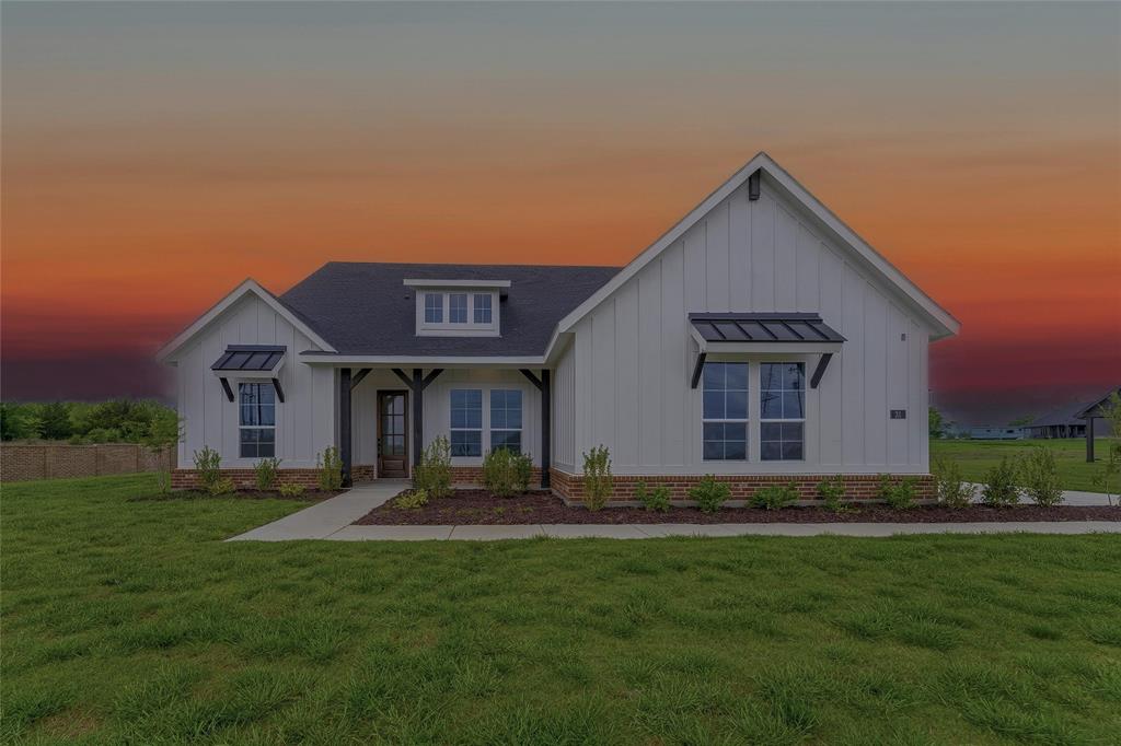 The property features a white exterior with board and batten siding, a dark roof, and brick accents