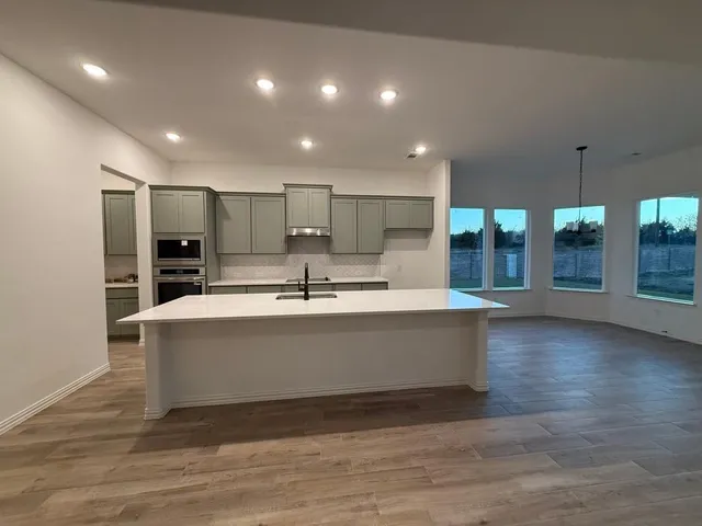 a view of kitchen with stainless steel appliances refrigerator sink and stove