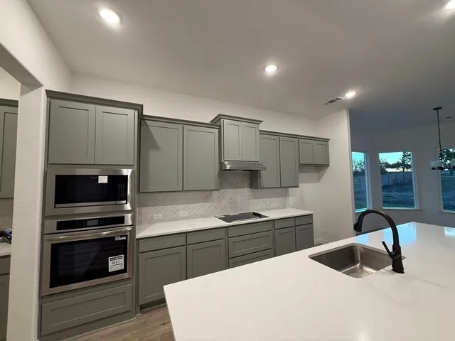 a kitchen with a sink and stainless steel appliances