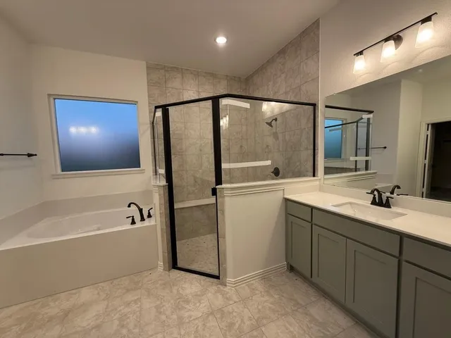 a bathroom with a tub sink and mirror