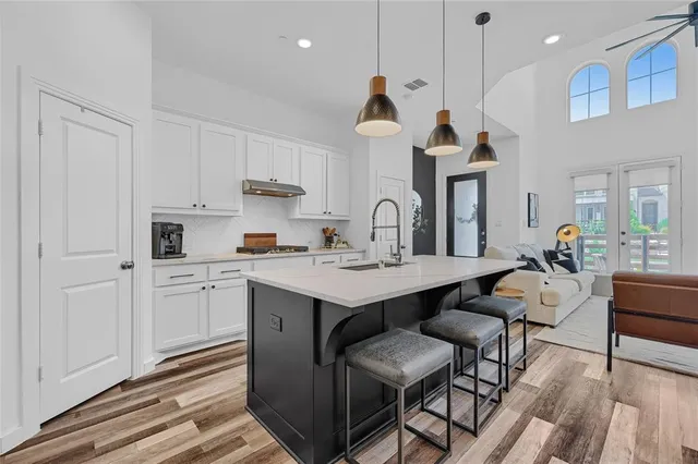 a kitchen with a sink cabinets and wooden floor