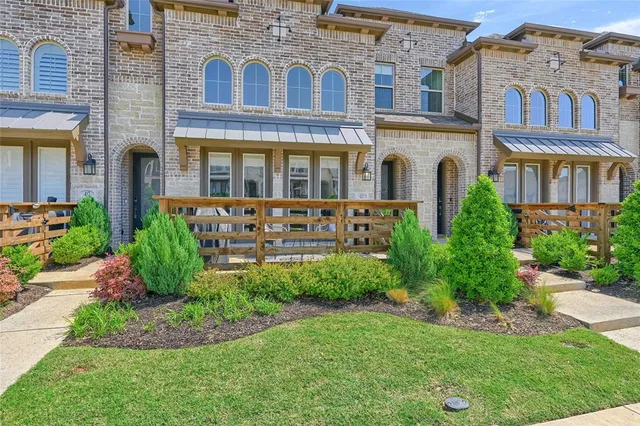 front view of a brick house with a yard