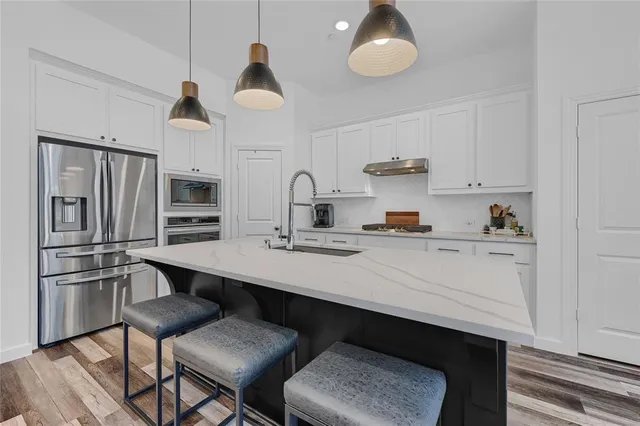 a kitchen with stainless steel appliances a sink and cabinets