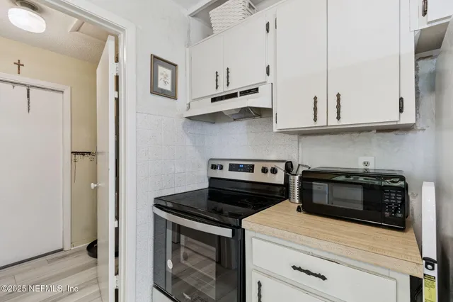 a view of a livingroom with wooden floor and a flat screen tv