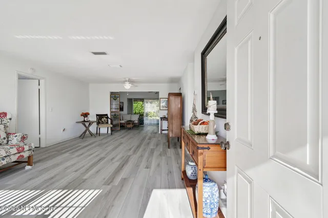 a living room with furniture a flat screen tv and a wooden floor