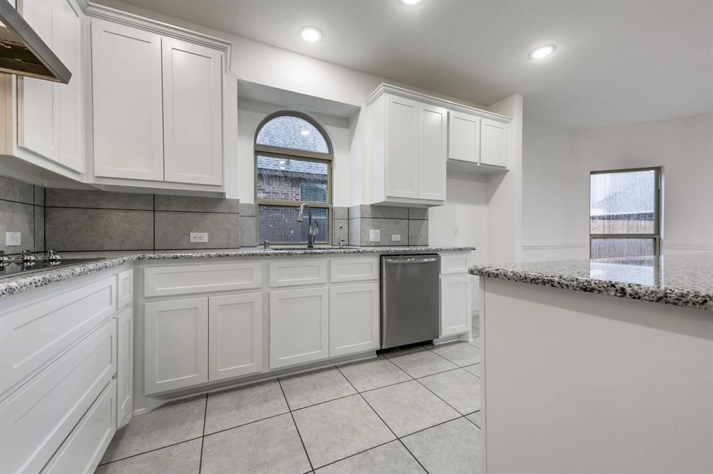 104 Sweetleaf Drive Red Oak, TX 75154 - Photo 15 of 36 The kitchen features white cabinetry, granite countertops, and a stainless steel dishwasher