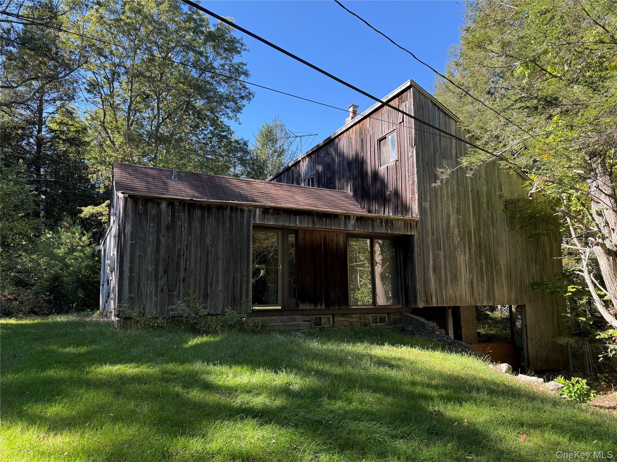 a view of a barn house next to a yard with large trees