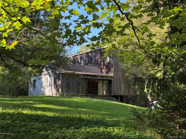 a front view of a house with a garden and trees