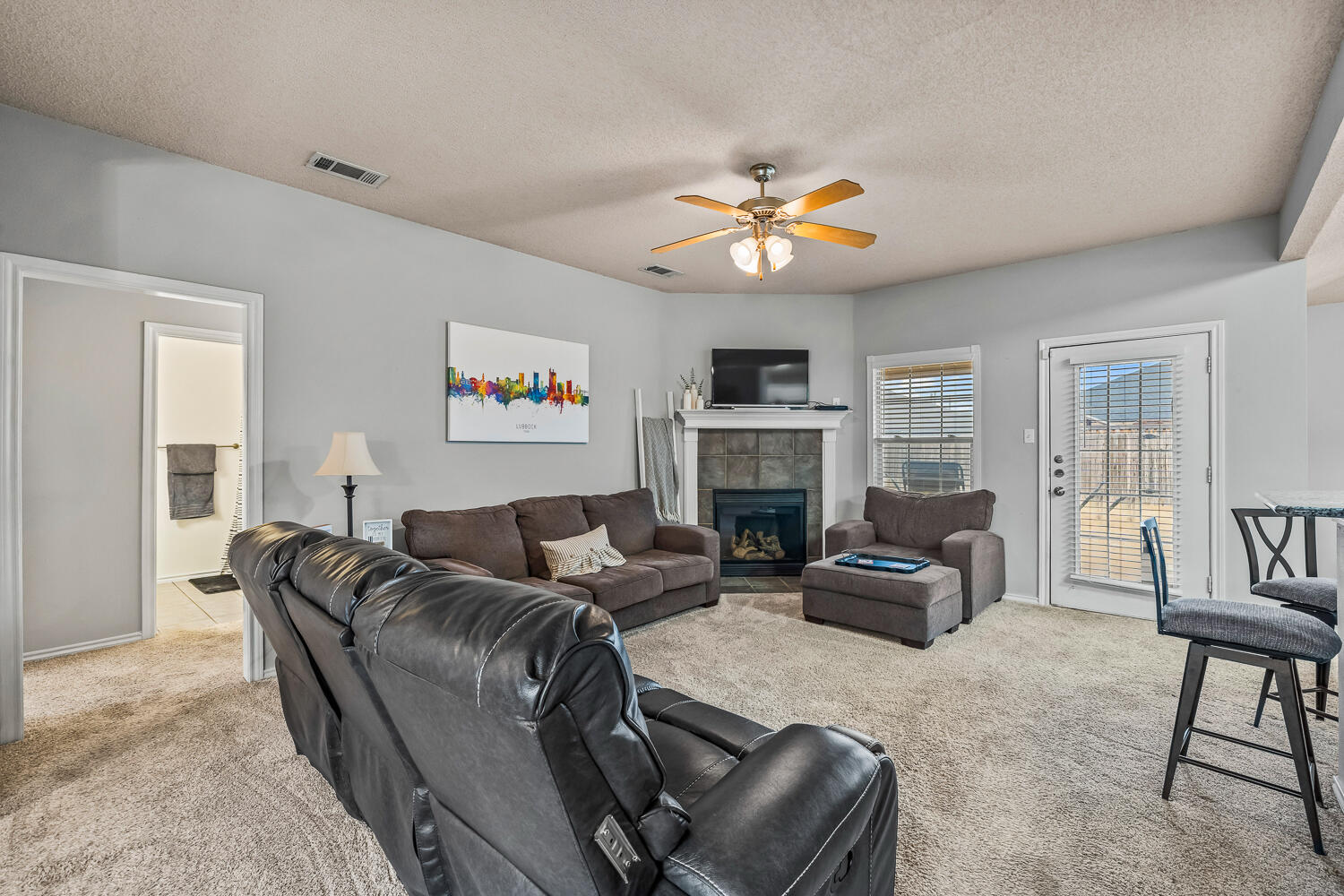 10607 Dover Avenue Lubbock, TX 79424 - Photo 11 of 34 a living room with furniture a fireplace and a flat screen tv