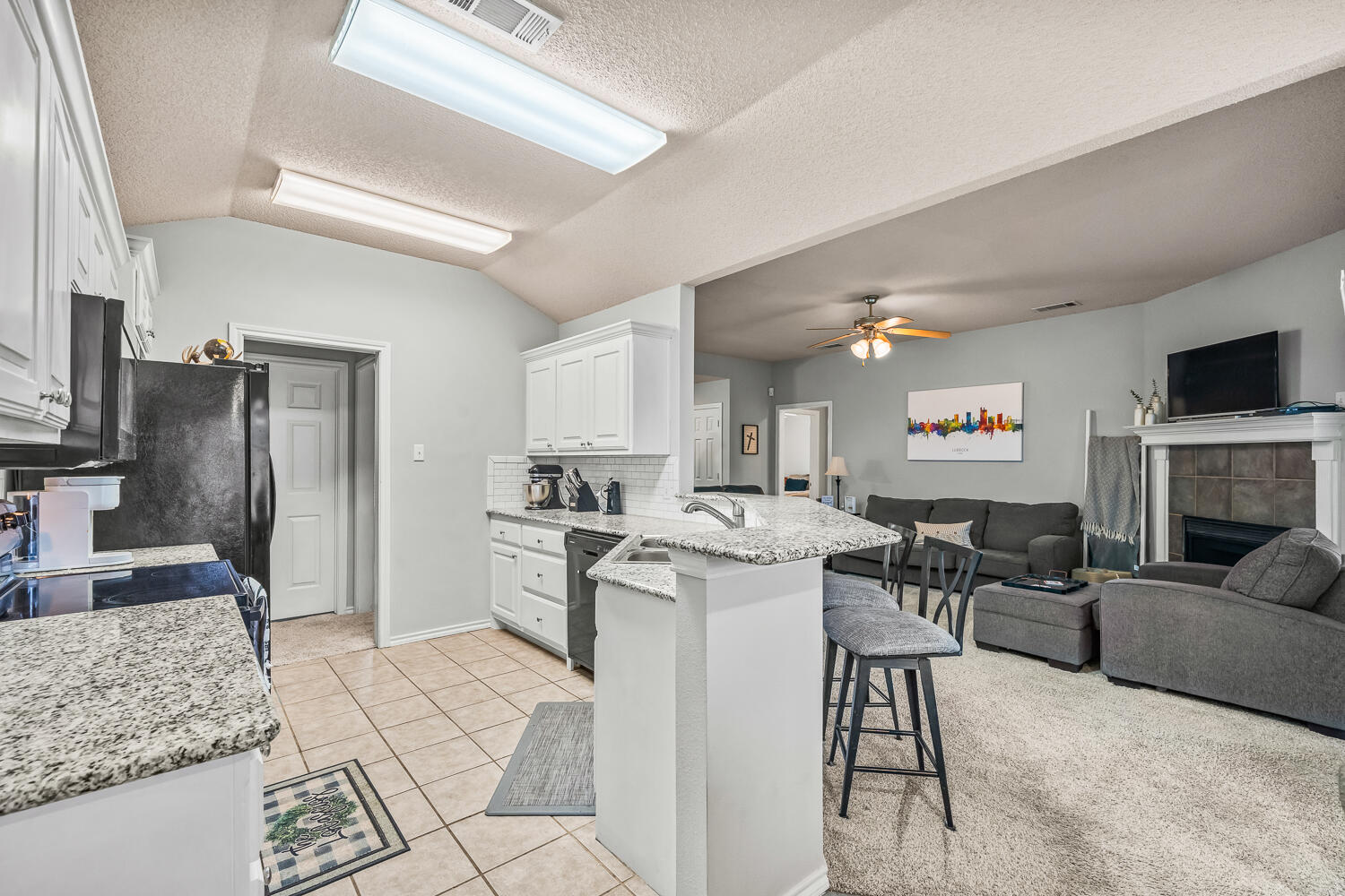 10607 Dover Avenue Lubbock, TX 79424 - Photo 12 of 34 a living room with stainless steel appliances kitchen island granite countertop furniture and a kitchen view