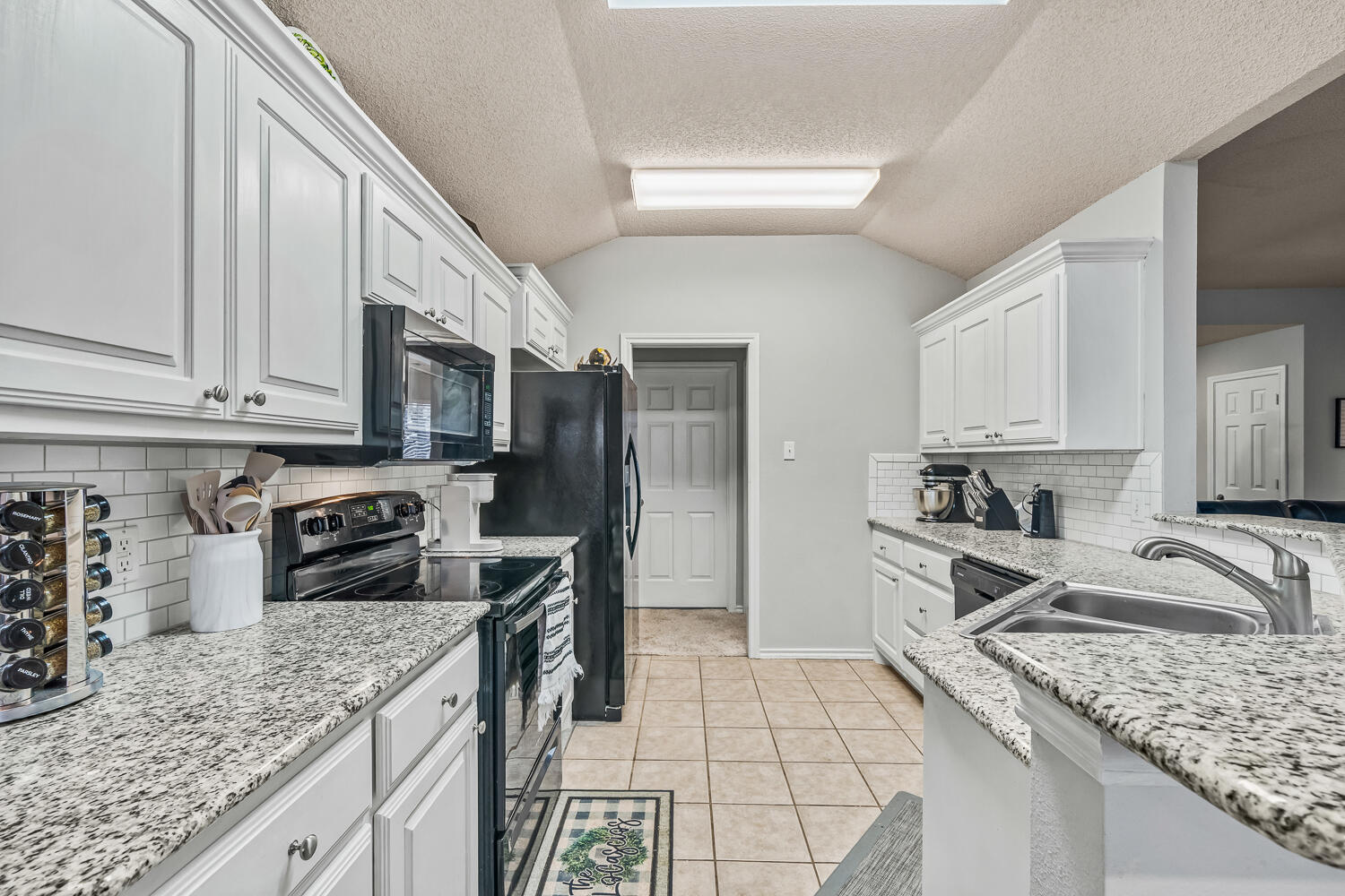 10607 Dover Avenue Lubbock, TX 79424 - Photo 13 of 34 a kitchen with stainless steel appliances granite countertop a sink stove and refrigerator