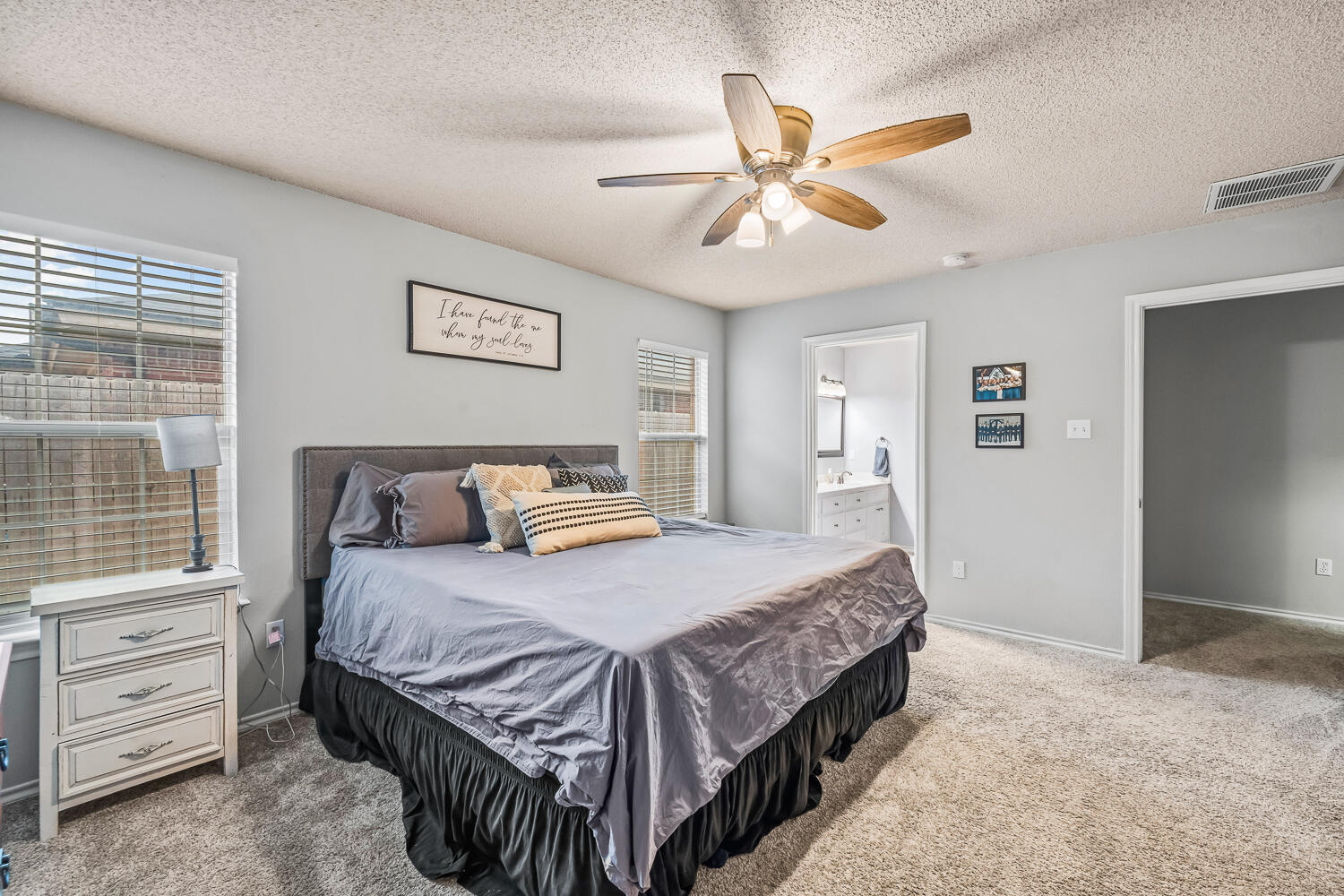 10607 Dover Avenue Lubbock, TX 79424 - Photo 18 of 34 a bedroom with a bed and a chandelier