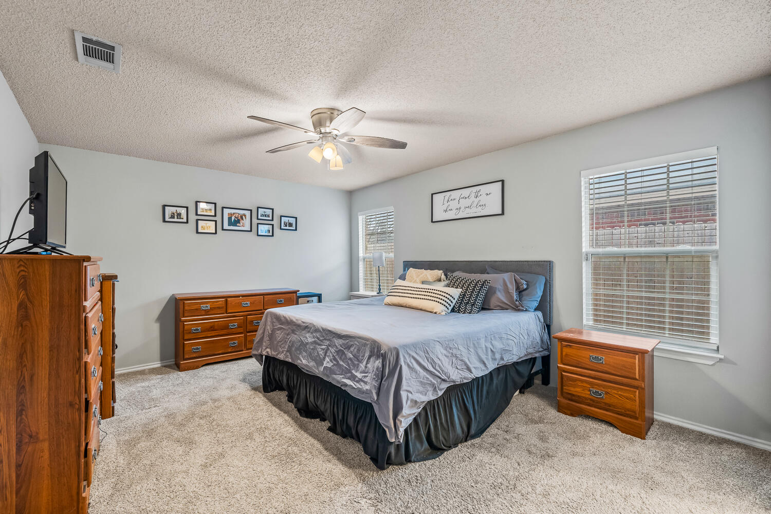 10607 Dover Avenue Lubbock, TX 79424 - Photo 19 of 34 a bedroom with a bed and a chandelier