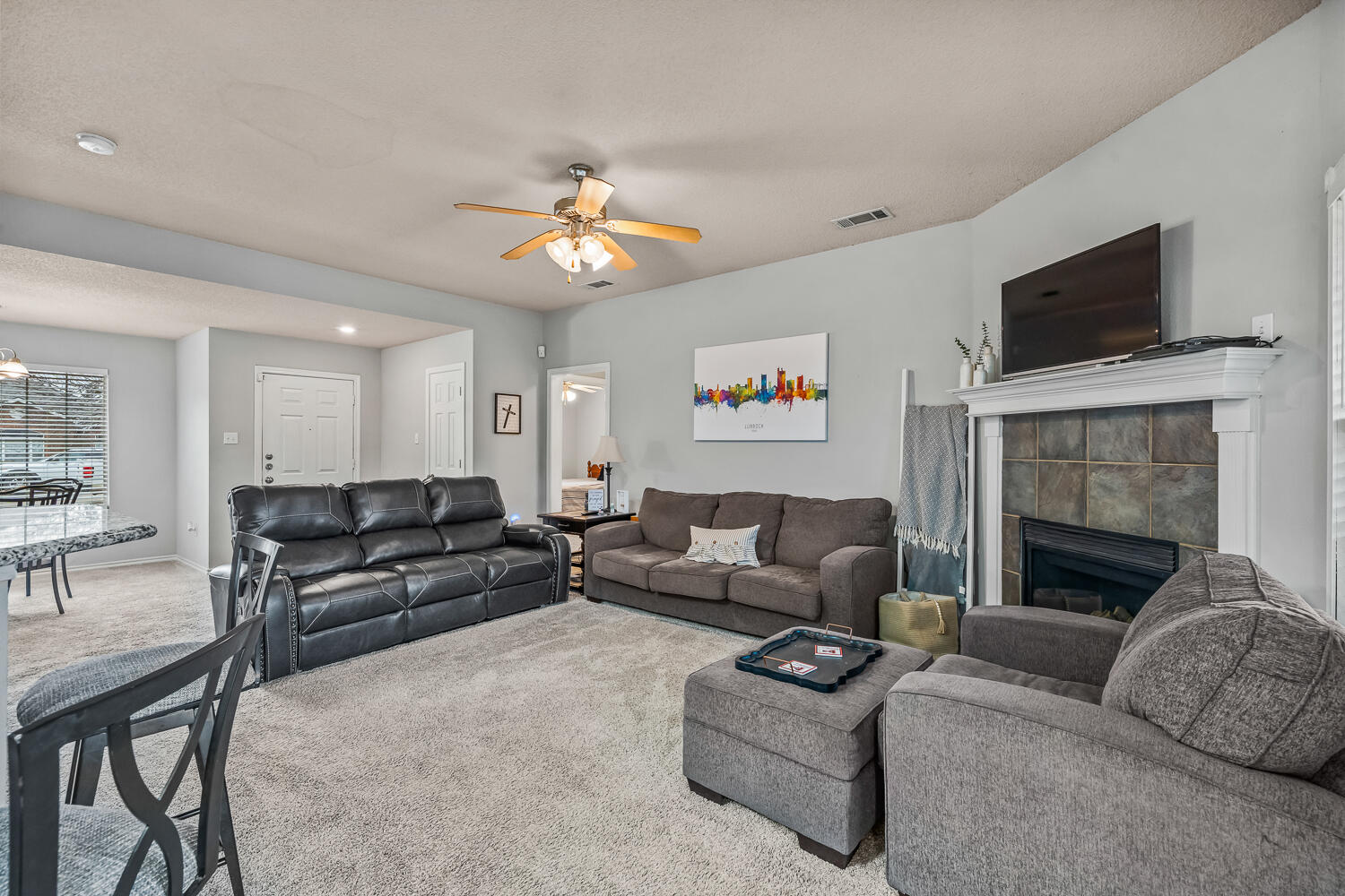 10607 Dover Avenue Lubbock, TX 79424 - Photo 6 of 34 a living room with furniture a flat screen tv and a fireplace
