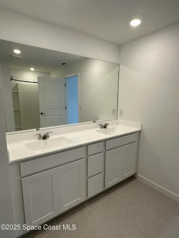 a bathroom with a double vanity sink and mirror