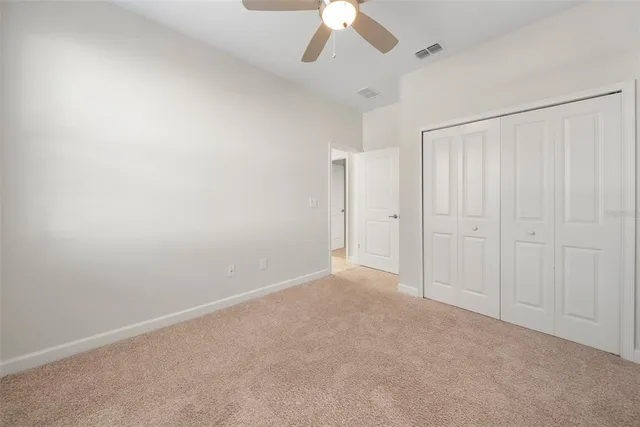 an empty room with a empty space and a ceiling fan