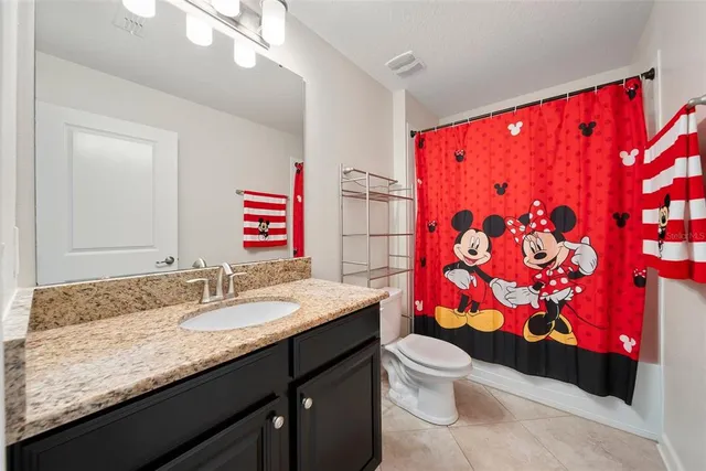 a bathroom with a sink vanity mirror and toilet