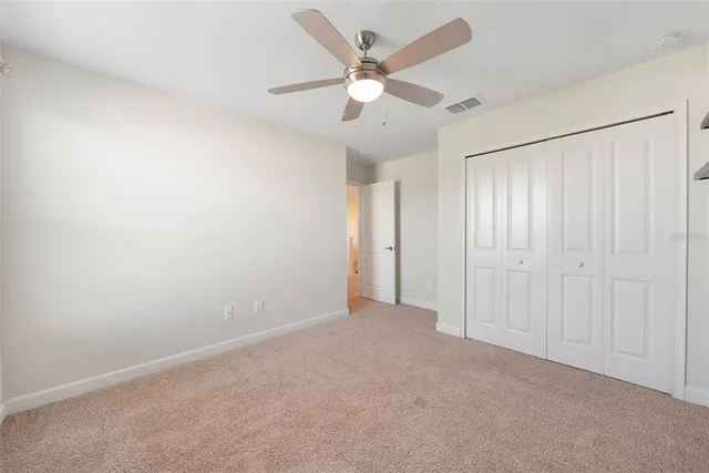an empty room with fan and windows