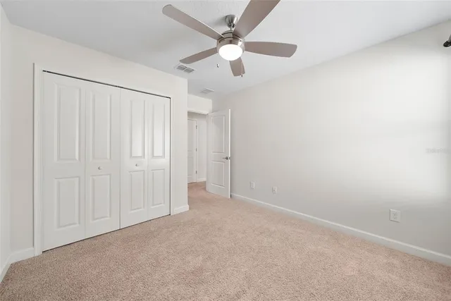 an empty room with chandelier fan