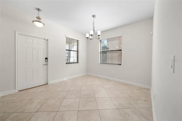 an empty room with windows and chandelier