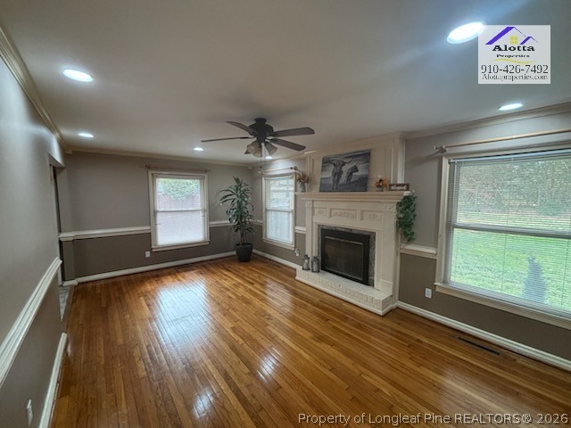 1817 McGougan Road Fayetteville, NC 28303 - Photo 14 of 24 an empty room with windows fireplace and wooden floor