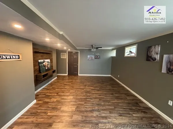 a view of empty room with wooden floor