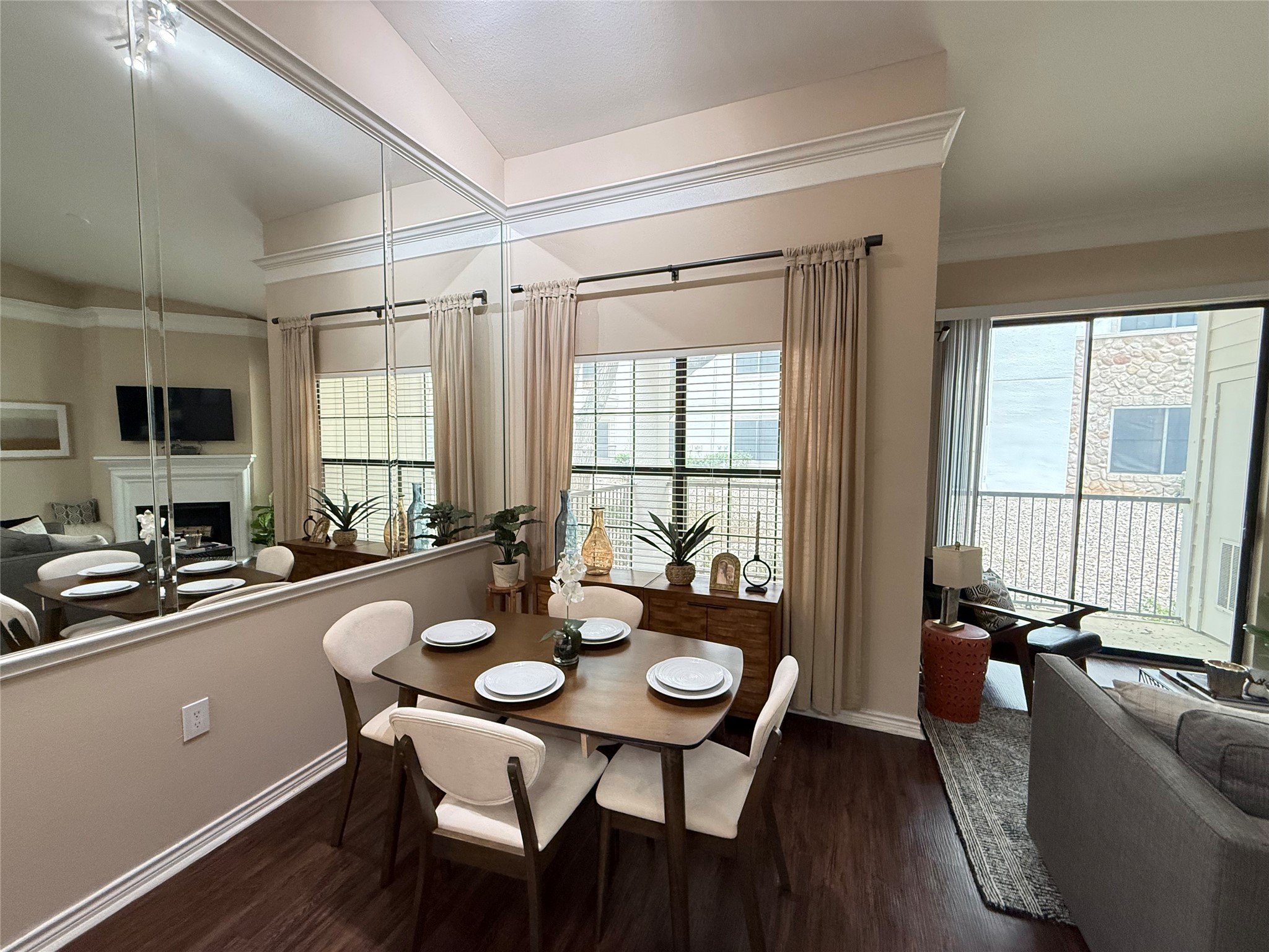 6607 Brodie Lane, Unit 535 Austin, TX 78745 - Photo 4 of 12 a view of a dining room and livingroom with furniture wooden floor a rug a flat screen tv a potted plant and a large window