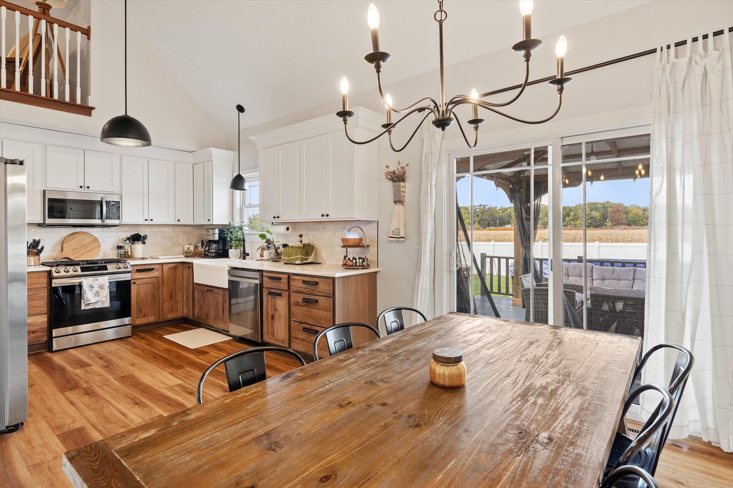 408 Coyote Trail Kouts, IN 46347 - Photo 12 of 36 a kitchen with kitchen island granite countertop a stove a sink a refrigerator with a dining table and chairs