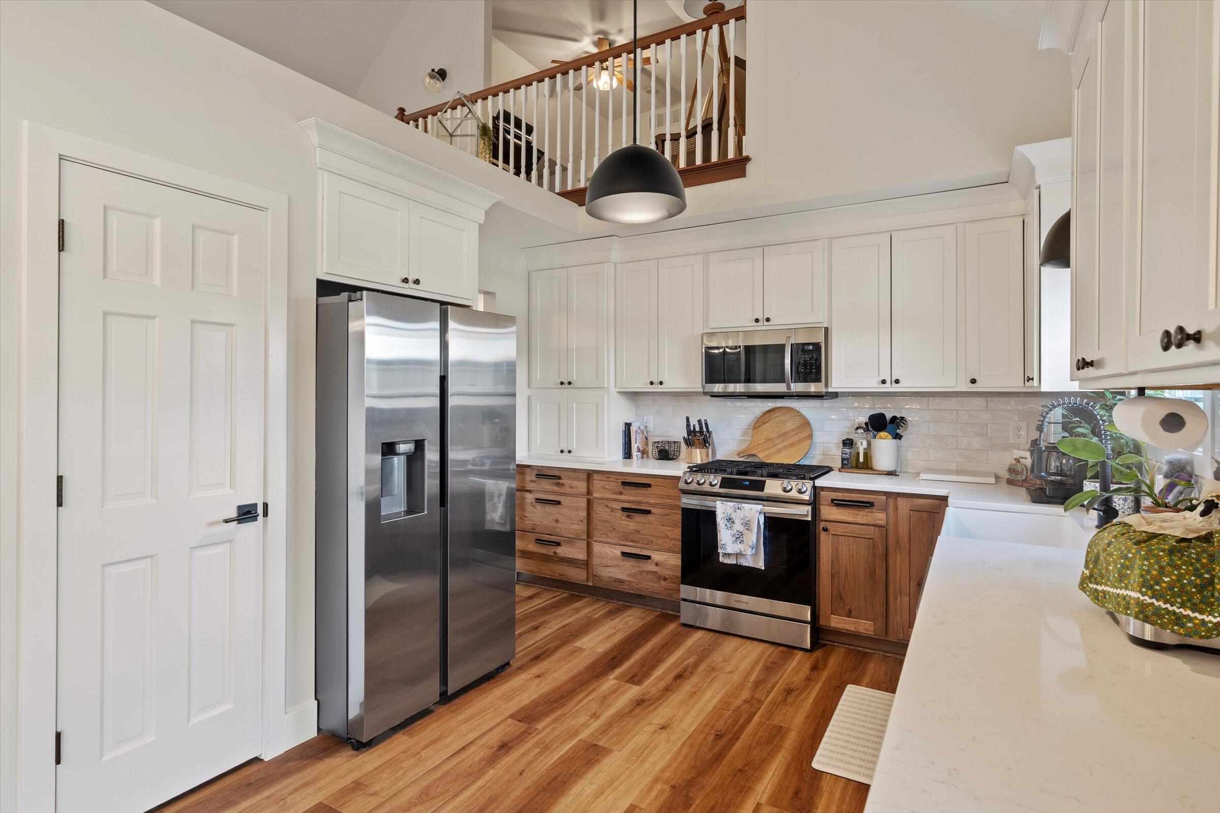 408 Coyote Trail Kouts, IN 46347 - Photo 17 of 36 a kitchen with stainless steel appliances granite countertop a refrigerator a stove top oven a sink dishwasher and white cabinets with wooden floor