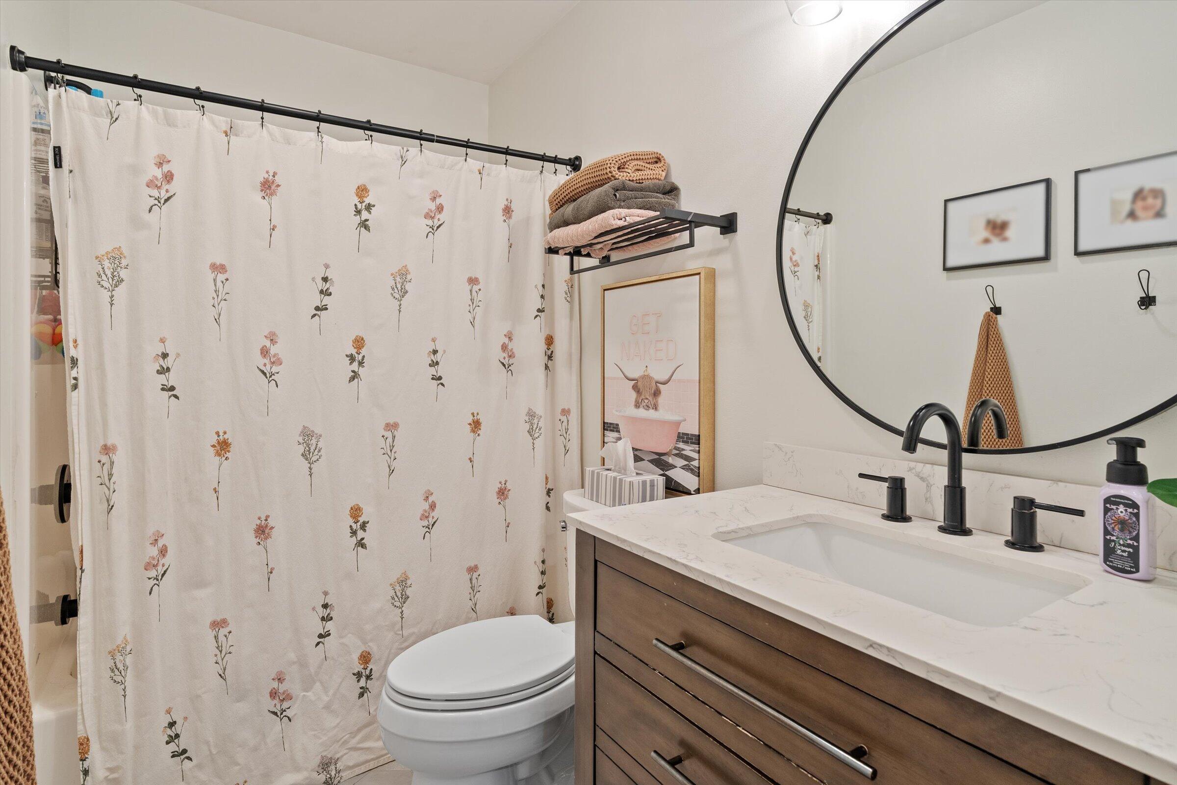 408 Coyote Trail Kouts, IN 46347 - Photo 29 of 36 a bathroom with a granite countertop sink a toilet and a mirror