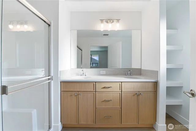 a bathroom with a double vanity sink and a mirror