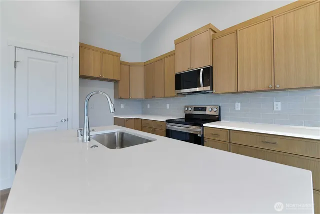 a kitchen with stainless steel appliances granite countertop a sink and a stove