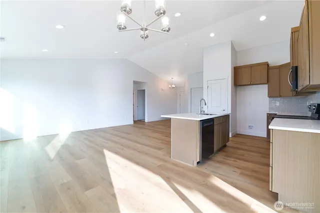 a large kitchen with kitchen island a sink stainless steel appliances and cabinets