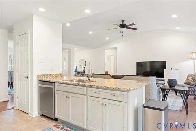 a view of a kitchen with kitchen island a sink stainless steel appliances and cabinets