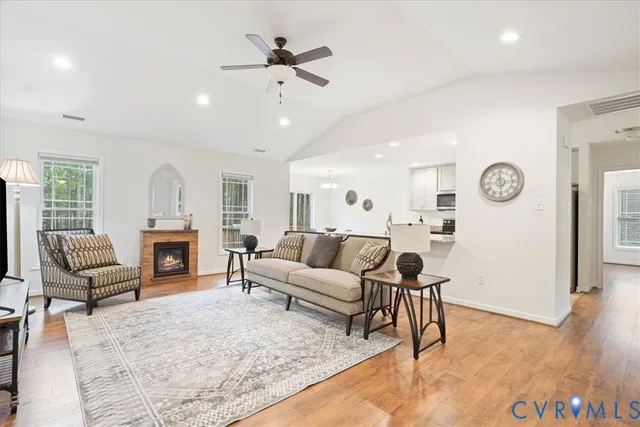 a living room with furniture a fireplace and a chandelier