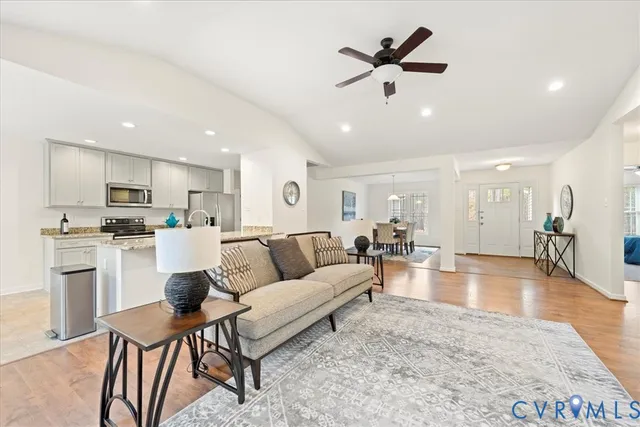 a living room with furniture kitchen view and a refrigerator