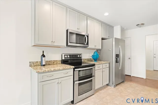 a kitchen with stainless steel appliances granite countertop a stove a refrigerator and a microwave