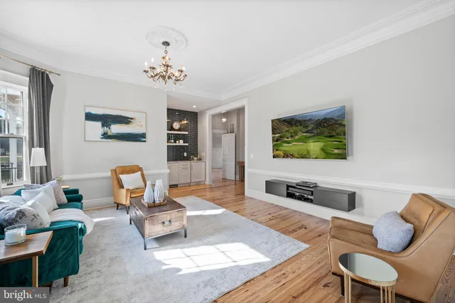 a living room with furniture a large window and a chandelier