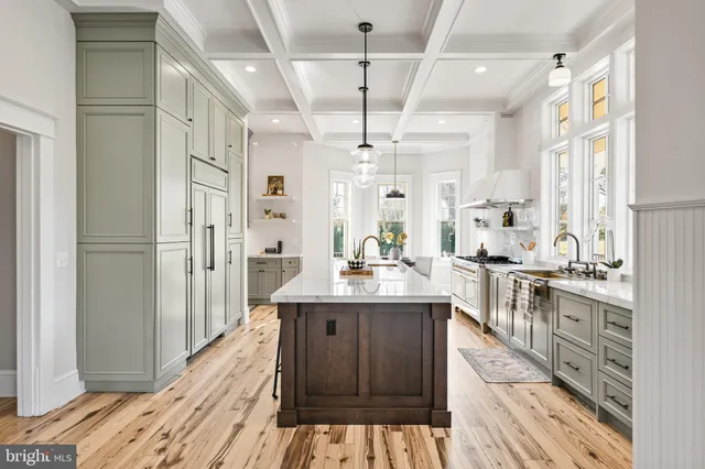 a kitchen with stainless steel appliances granite countertop a sink a counter top space and living room view
