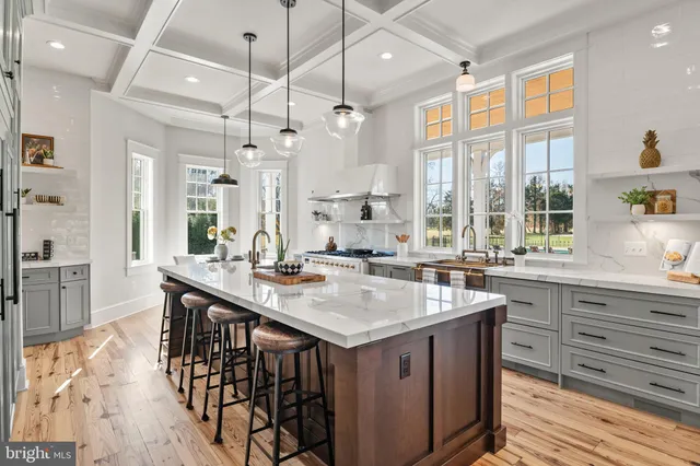 a spacious bedroom with a bed a dresser and wooden floor