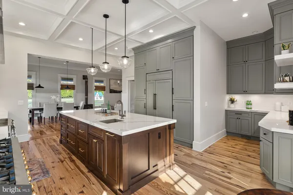 a kitchen with stainless steel appliances granite countertop a sink a counter top space and living room view