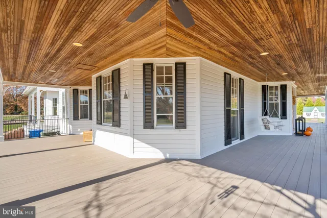a dining room with wooden floor a chandelier a wooden table and chairs