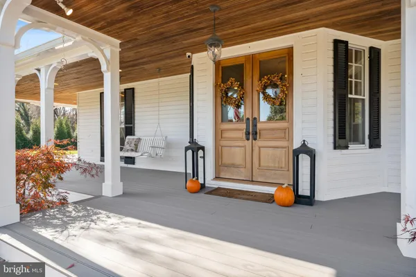 a dining room with wooden floor a chandelier a wooden table and chairs