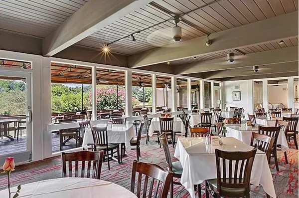 a room with lots of wooden furniture and large windows