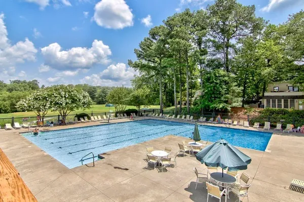 a view of backyard with swimming pool and seating space