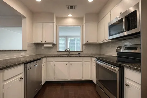 a kitchen with stainless steel appliances granite countertop a stove microwave and sink